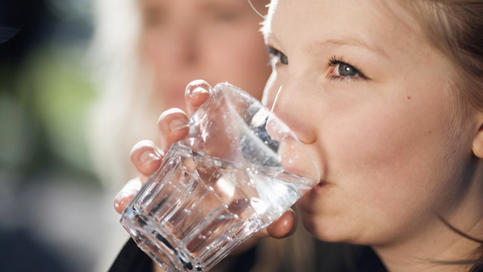 Barn som dricker vatten ur ett glas. Foto: Scandinav bildbyrå.